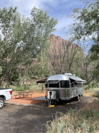 an rv parked in a parking lot with trees in the background