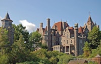 a large stone castle sits on top of a hill