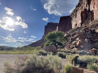 the sun is shining on a rocky cliff