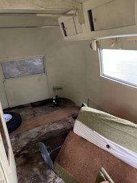 the inside of an rv with a bed and a window