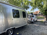 a silver airstream trailer parked next to a truck