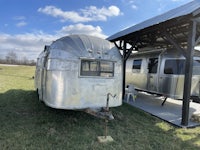 a silver airstream parked in a grassy area