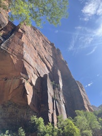 a rock formation with trees and a blue sky