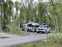 an airstream parked in a wooded area