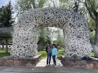 two people standing in front of an antler arch