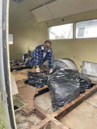a man working in a room with a lot of trash
