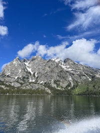 a boat on a lake with mountains in the background